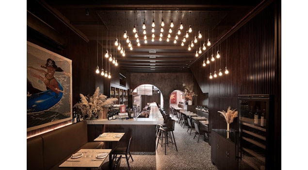 Experience the Essence of Venetian Design and Hospitality at Bar Cicheti, Singapore, design by Studio Königshausen. This Singaporean gem features a minimalist interior adorned with classic bistro elements, paying homage to Venetian Gothic architecture. 